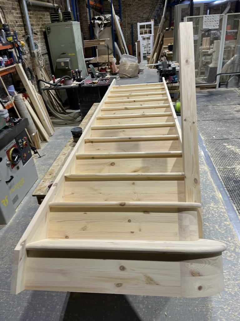 Wooden staircase under construction in workshop