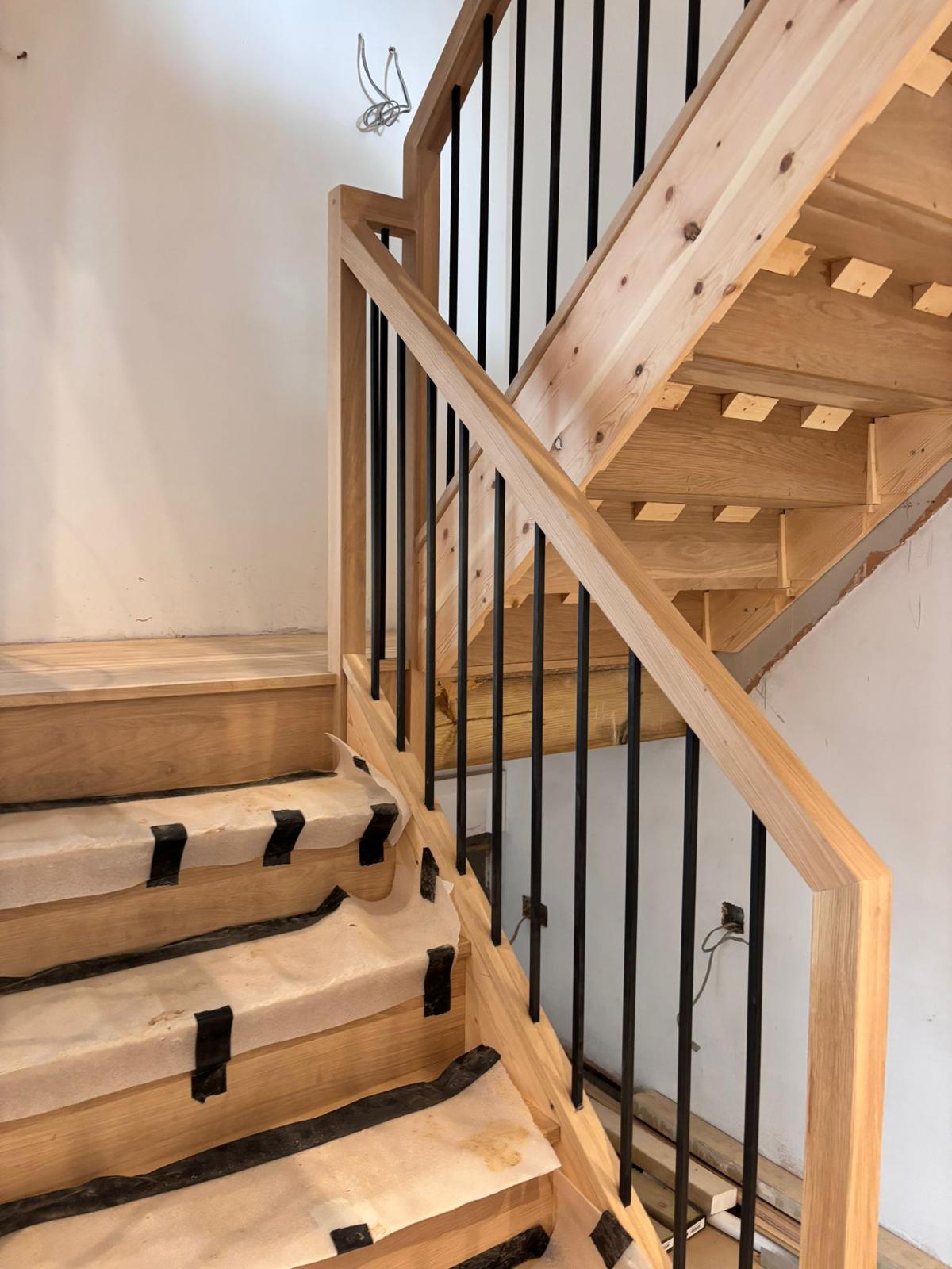 Wooden staircase with black metal spindles