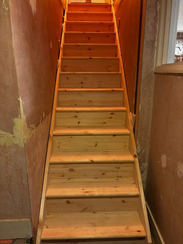 Wooden stairs in dimly lit hallway
