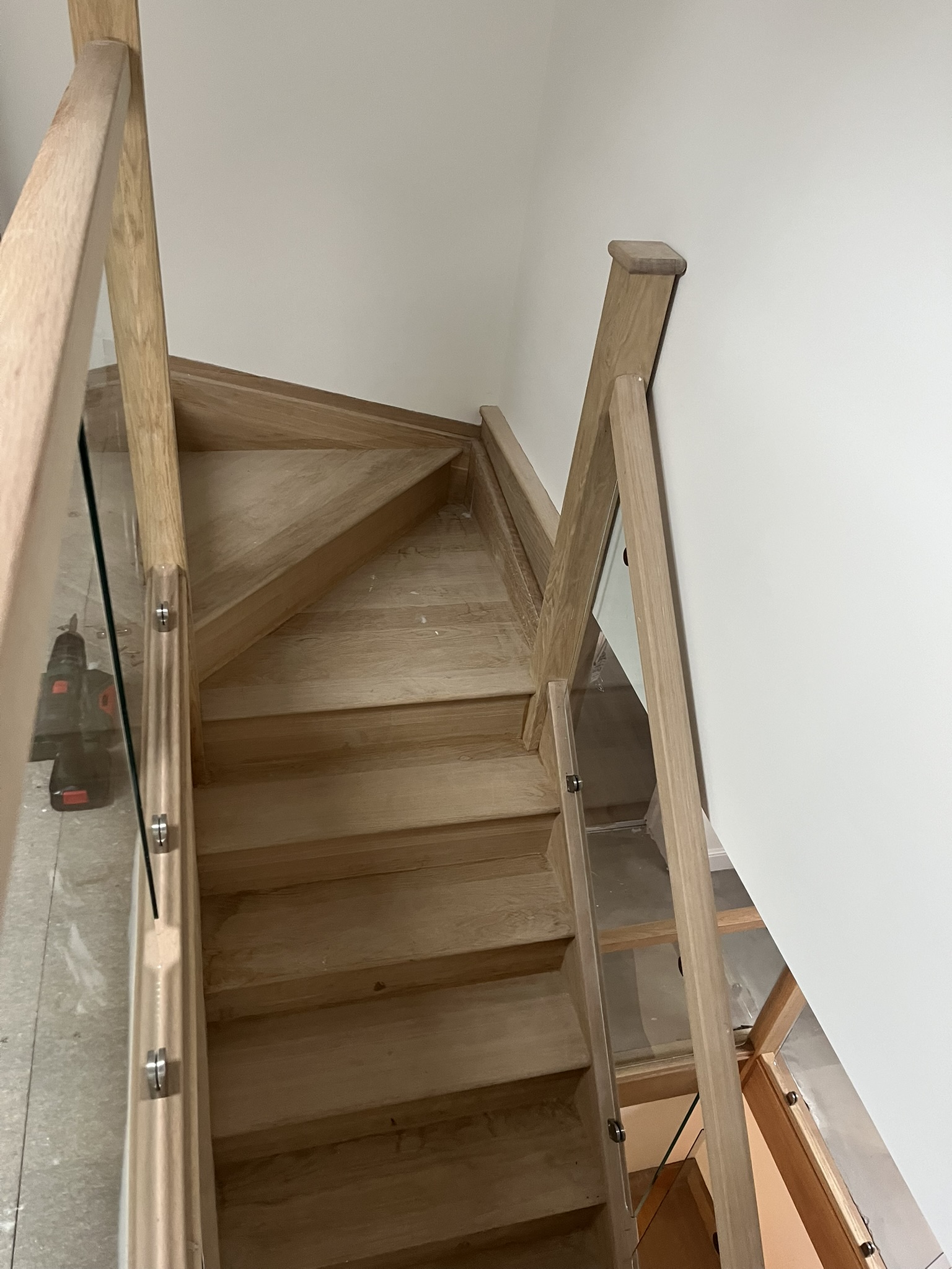 Wooden staircase with glass railing corner
